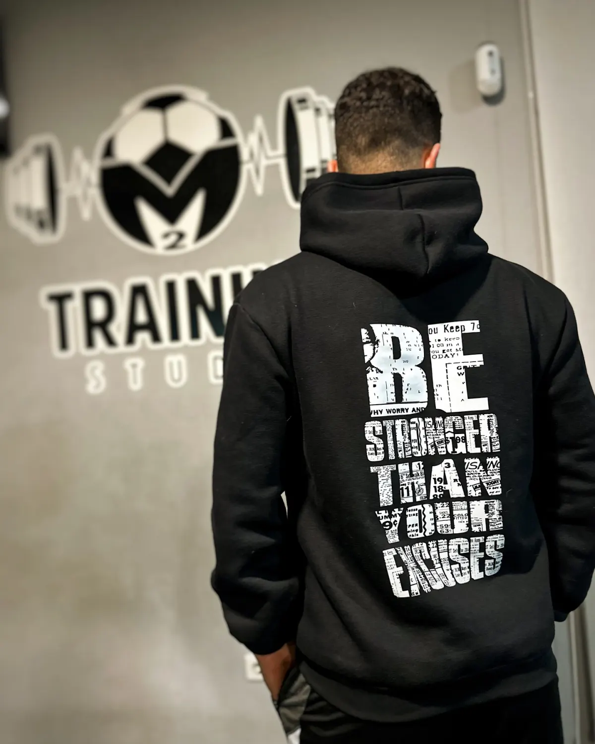 Hoodie da equipa com a frase Be stronger than your excuses, de costas para o logótipo